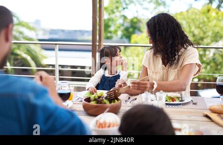 Nous avons toujours le meilleur des temps ensemble. Une adorable petite fille et sa mère s'appréciant pendant un repas avec la famille dehors. Banque D'Images