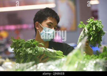 HANGZHOU, CHINE - 10 AOÛT 2022 - les clients choisissent des légumes dans un supermarché à Hangzhou, province du Zhejiang, Chine, 10 août 2022. Prix à la consommation Banque D'Images