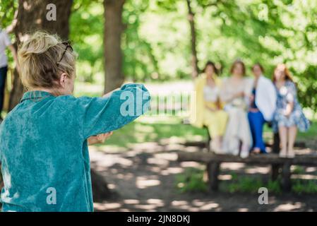 Un photographe de mariage prend des photos des invités de la mariée et du marié dans la nature, par une journée ensoleillée Banque D'Images