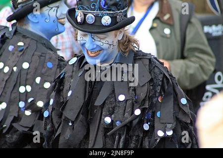 SIDMOUTH, DEVON, Royaume-Uni - 8 AOÛT 2017 les artistes du Sidmouth Folk Festival de Boggart's Breakfast aux visages bleus peints et aux vêtements noirs Banque D'Images