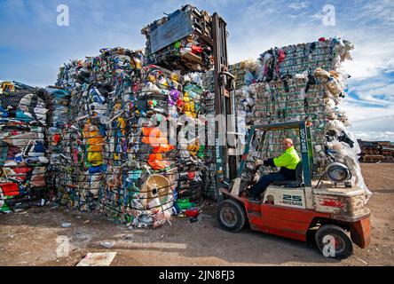 Chariot élévateur à fourche empilant des balles de divers plastiques pour recyclage dans une usine de recyclage à Geelong, Victoria Banque D'Images