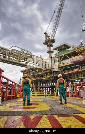 navire approchant la zone de 500 mètres de la plate-forme pétrolière après avoir reçu la permission de la plate-forme pétrolière avec deux personnes en attente sur le pont Banque D'Images