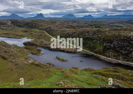 Vue sur une route côtière et un paysage sur la route panoramique North Coast 500 dans les Higlands écossais près de Lochniver Banque D'Images