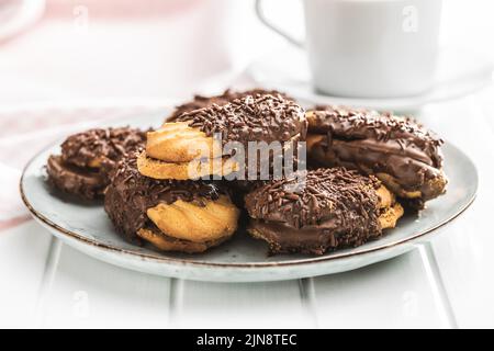 Petits fours à saupoudrer de chocolat. Mini dessert au chocolat sur une assiette. Banque D'Images