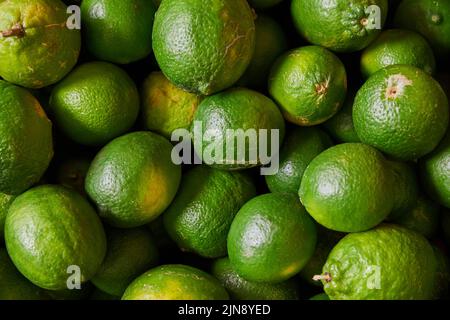 Citrons verts placés sur une étagère pour la vente sur un marché Banque D'Images