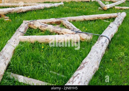 connexion à bande en acier forgé de poutres en bois pour cadre de poutre de support de toit posé sur l'herbe verte le jour de l'été Banque D'Images