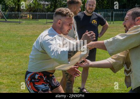 Les entraîneurs enseignent les règles et techniques de la Wrestling cornish avant le début du Grand Tournoi de la Wrestling cornish sur le village pittoresque g Banque D'Images