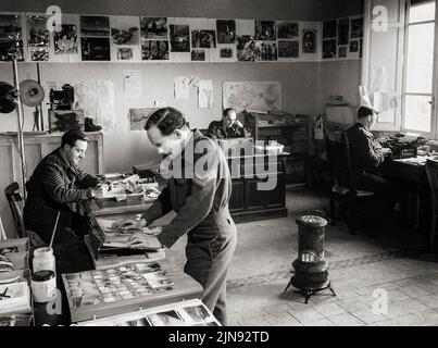 Intérieur du Bureau photographique de l'unité des relations publiques (outre-mer) de la RAF au quartier général des Forces alliées à Caserta, en Italie, où le personnel est vu trier et sous-tirer des tirages de photographies officielles de la RAF pour distribution aux médias. Banque D'Images