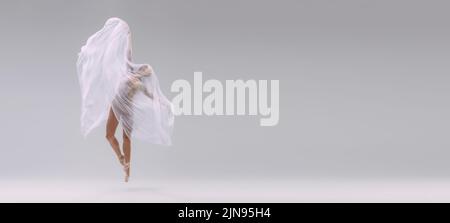 Portrait de jeune ballerine recouvert de tissu blanc transparent et danse isolée sur fond gris de studio. Artiste gracieuse Banque D'Images