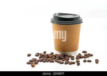 Café chaud à emporter en papier marron avec grains de café sur le sol, café chaud isolé à emporter en papier marron sur fond blanc. Espace vide sur la tasse f Banque D'Images