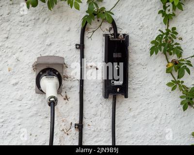 HATHERLEIGH, DEVON, ANGLETERRE - AOÛT 9 2022 : un point de chargement pour une voiture électrique installée dans un cadre domestique. Marque: Ohme. Banque D'Images