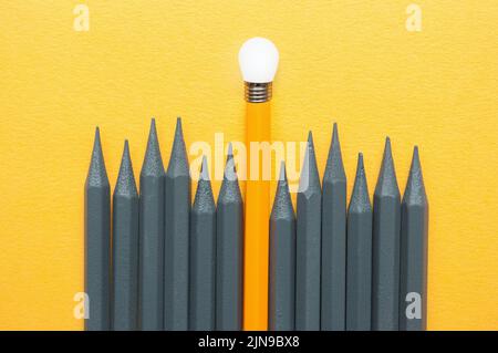 Crayon orange se distingue parmi les crayons gris avec la pointe de l'ampoule, idées uniques succès concept Banque D'Images