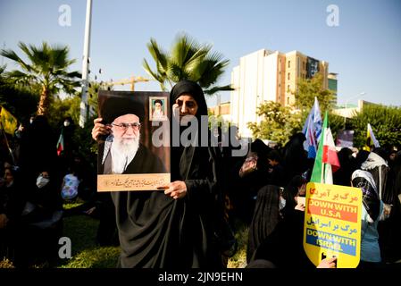 Téhéran, Iran. 09th août 2022. Une jeune femme tient une affiche avec des portraits du Guide suprême de l'Iran, l'ayatollah Ali Khamenei, lors d'une manifestation contre Israël dans le centre-ville de Téhéran, en Iran, le 9 août 2022. (Photo de Sobhan Farajvan/Pacific Press/Sipa USA) crédit: SIPA USA/Alay Live News Banque D'Images