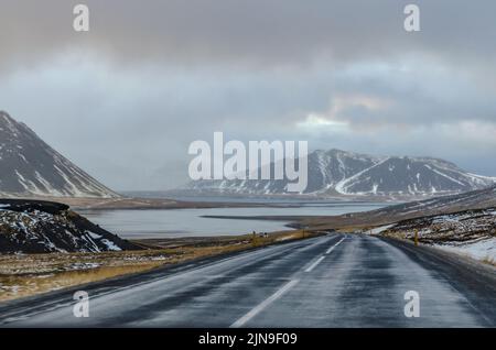 En voiture à travers l'Islande par une journée hivernale froide et pluvieuse, chaque courbe de la route révèle des vues de proportions épiques, qu'il s'agit de montagnes, de fjords ou de valle Banque D'Images