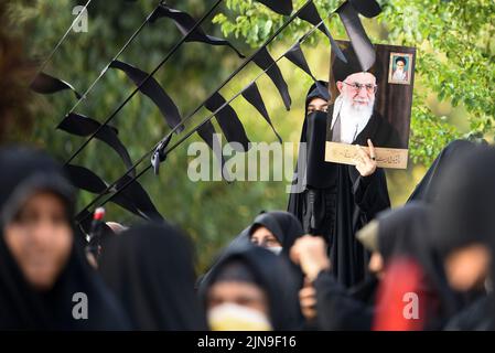Téhéran, Iran. 09th août 2022. Une jeune femme tient une affiche avec des portraits du Guide suprême de l'Iran, l'ayatollah Ali Khamenei, lors d'une manifestation contre Israël dans le centre-ville de Téhéran, en Iran, le 9 août 2022. (Photo de Sobhan Farajvan/Pacific Press/Sipa USA) crédit: SIPA USA/Alay Live News Banque D'Images