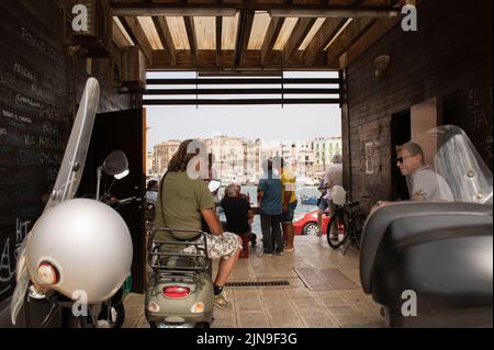 Les habitants bavardent sur la jetée du port de Bari Banque D'Images