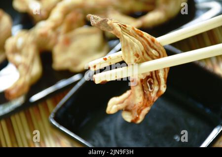 croquants de canard frits sur l'assiette trempés avec de la sauce au soja noire douce Banque D'Images