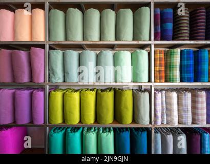 Les rouleaux de soie tissés à la main de style thaïlandais traditionnel sont sur des étagères à l'intérieur d'un magasin de vêtements local en Thaïlande, vue de face avec l'espace copie. Banque D'Images