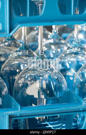 Boîtes en plastique bleu avec verres à vin brillants pour les restaurants à l'envers et reflétant la lumière Banque D'Images