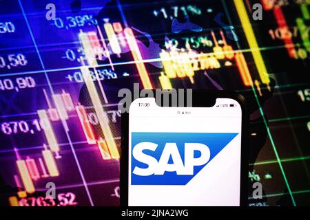 KONSKIE, POLOGNE - 09 août 2022: Smartphone affichant le logo de la société SAP se sur fond de diagramme boursier Banque D'Images