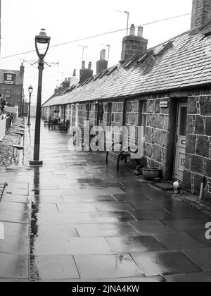 Le petit village de pêcheurs pittoresque de Footdee, dans la ville d'Aberdeen, en Écosse, en noir et blanc par temps froid et pluvieux Banque D'Images