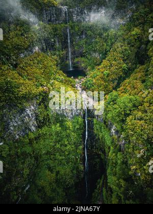 Vue aérienne de la chute d'eau de Risco dans une forêt verdoyante, Rabacal, Paul da Serra, Madère, Portugal Banque D'Images