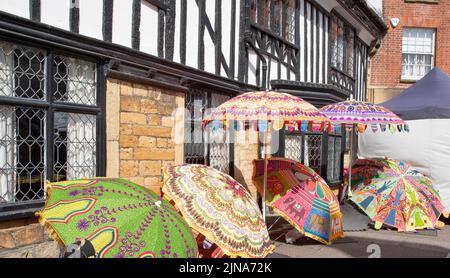 Parasols à vendre à l'extérieur d'un bâtiment à pans de bois, marché Sherborne Banque D'Images