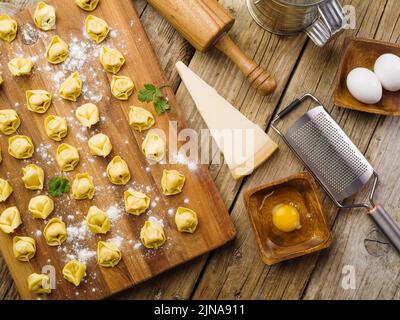 Cuisson de boulettes maison farcies à la viande hachée. Petits boulettes sur une planche à découper en bois, ustensiles de cuisine et ingrédients. Beaucoup d'objets. Hom Banque D'Images