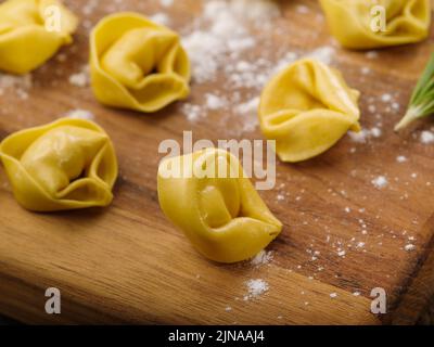 Gros plan. Boulettes maison, raviolis farcis à la viande hachée sur une planche à découper en bois. Le processus de fabrication de raviolis faits maison, boulettes de viande Banque D'Images