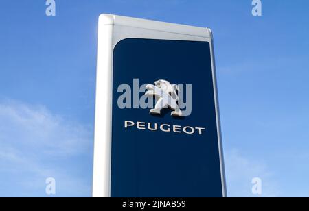 Logo de la société automobile Peugeot. Symbole français du constructeur automobile. Enseigne sur poteau de la piste de l'établissement concessionnaire avec logo de la marque de l'entreprise. Banque D'Images