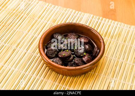 Chorizo ​​in vin, tapas et cuisine espagnole typique dans un pot en argile. Banque D'Images