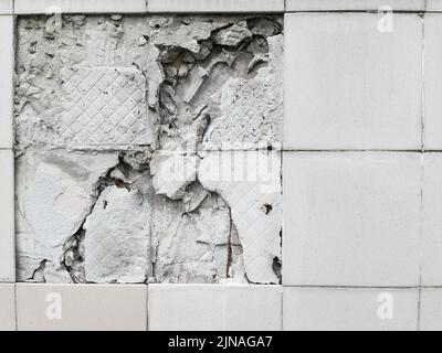 Un mur avec un carreau gris cassé du mur en plein écran Banque D'Images