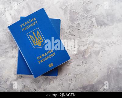 Deux passeports biométriques ukrainiens sur fond clair. Voyage des Ukrainiens à l'étranger, tourisme, émigration, fuite de la guerre en Ukraine. ID personnel Banque D'Images