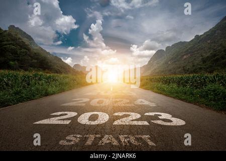 2023, le nouvel an 2023 ou le début du concept du mot 2023 est écrit sur la route au milieu de la route asphaltée avec un mounta au coucher du soleil Banque D'Images