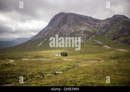 Les hauts plateaux de l'Écosse avec une petite maison dans le milieu Banque D'Images