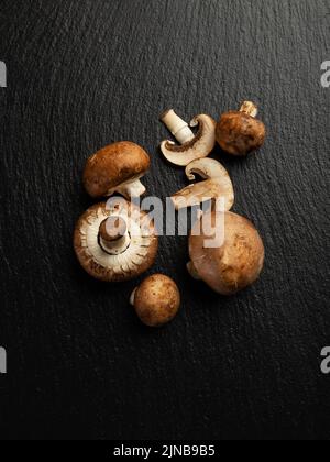 Quelques champignons comestibles en ardoise, vue de dessus Banque D'Images