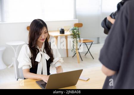 Une femme japonaise qui travaille avec un photographe dans le bureau à domicile Banque D'Images