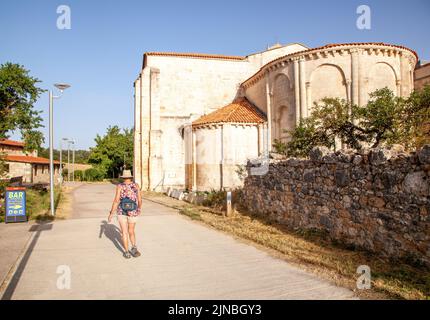 Femme marchant sur la route de pèlerinage de Camino de Santiago le chemin de St James à travers la campagne espagnole à travers San Jaun de Ortega sur le chemin de Burgos Banque D'Images