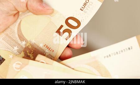 Homme comptant de l'argent. Gros plan des mains masculines comptant un tas de 50 billets en euros. Change de devises étrangères. Calcul de l'argent comptant. Concept de salaire. Banque D'Images