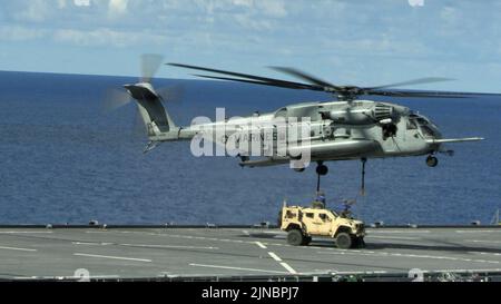 Un US Marine CH-53E Super Stallion, avec Marine Medium Tiltrotor Squadron 262 (rein.), 31st Marine Expeditionary Unit, est attaché à un véhicule tactique léger conjoint par Marines du combat Logistics Battalion 31 à bord de la base mobile expéditionnaire USS Miguel Keith (ESB-5) en mer des Philippines, le 8 août 2022. Cet exercice prouve que le MEU 31st peut apporter des équipements lourds même dans les endroits les plus éloignés. Le MEU de 31st opère à bord de navires du Groupe amphibie Ready de Tripoli dans la zone d'opérations de la flotte de 7th pour améliorer l'interopérabilité avec les alliés et les partenaires et servir de réponse prête à l'emploi Banque D'Images