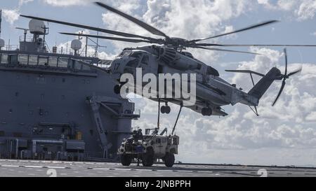 Les Marines des États-Unis avec le Medium Tiltrotor Squadron 262 (rein.) et le combat Logistics Battalion 31, 31st Marine Expeditionary Unit ont sécurisé un véhicule tactique léger conjoint à un CH-53E Super Stallion à bord de la base mobile expéditionnaire USS Miguel Keith (ESB-5) lors d'un exercice d'équipe de soutien d'hélicoptère en mer des Philippines, le 8 août 2022. Les HSTs permettent de configurer une zone de dépôt rapide pour le ramassage et le transport d'équipements lourds en vol. Le MEU de 31st opère à bord de navires du Groupe amphibie Ready de Tripoli dans la zone d'opérations de la flotte de 7th afin d'améliorer l'interopérabilité avec les alliés et les partenaires Banque D'Images