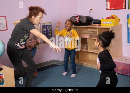 Éducation préscolaire garde d'enfants 4 ans visting enseignant de yoga travaillant avec un petit groupe de filles Banque D'Images