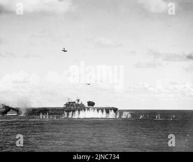 Un bombardier japonais endommagé (en haut à gauche) plonge vers le porte-avions USS Hornet de la Marine américaine pendant la bataille de Santa Cruz, le 26 octobre 1942. Banque D'Images