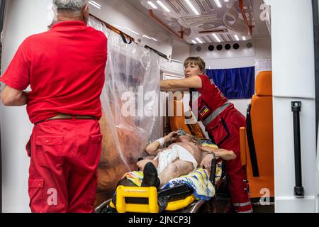 Un homme âgé reçoit des soins médicaux des ambulanciers paramédicaux avant de monter à bord du train d'évacuation à la gare de Pokrovsk. Dans le contexte de l'intensification des combats dans la partie orientale de l'Ukraine, l'Ukraine de l'est intensifie maintenant son évacuation civile, car des millions de familles ukrainiennes ont été évacuées de la guerre plus proche et plus étroite, car beaucoup d'entre elles seront déplacées dans la partie occidentale du pays. Selon les Nations Unies, au moins 12 millions de personnes ont fui leurs foyers depuis l'invasion de l'Ukraine par la Russie, tandis que sept millions de personnes sont déplacées à l'intérieur du pays. Banque D'Images