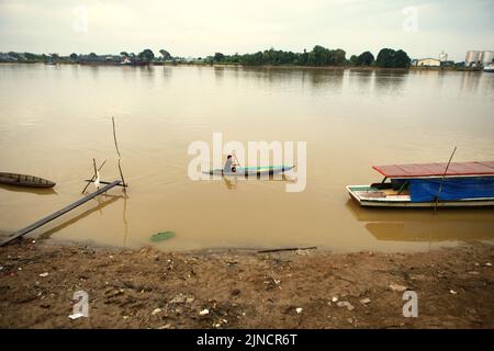 Un villageois voyage en ramer un bateau sur la rivière Batangari dans le village de Muara Jambi, Muaro Jambi, Jambi, Indonésie. Banque D'Images