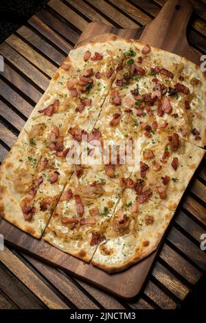 Pizza rectangulaire Flamkuchen tarte flambee avec bacon et poulet sur fond de table en bois Banque D'Images