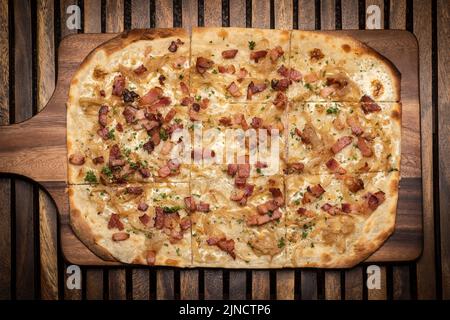 Pizza rectangulaire Flamkuchen tarte flambee avec bacon et poulet sur fond de table en bois Banque D'Images