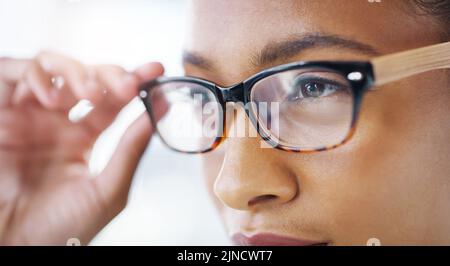 Elle voit que le succès est en route. Gros plan d'une jeune femme d'affaires attirante portant des lunettes dans un bureau moderne. Banque D'Images