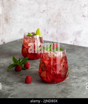Limonade d'été fraîche à la framboise, au citron vert, à l'eau de soude et à la glace en verre. Banque D'Images
