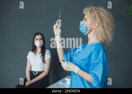 Une infirmière vaccine un patient contre une infection à coronavirus. Vaccination contre le coronavirus. Virus, épidémie, maladie. Banque D'Images